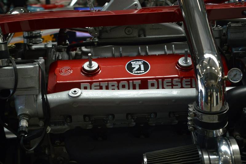 Close-up of a red diesel engine with chrome intake piping.